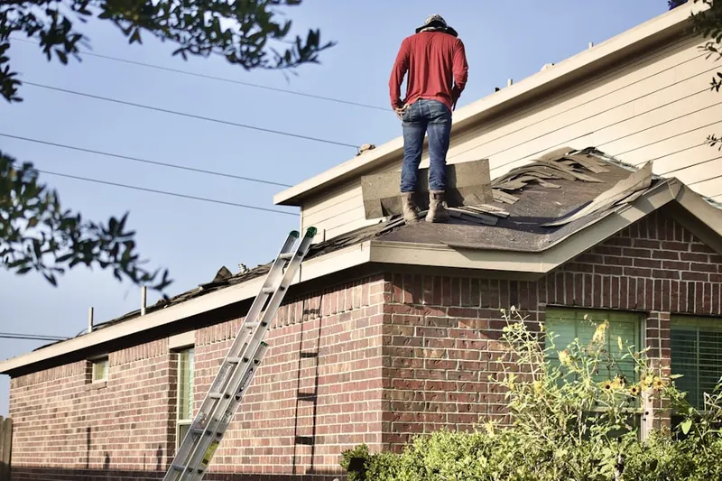 Professional roofer working on a residential roof in Rock Raymond
